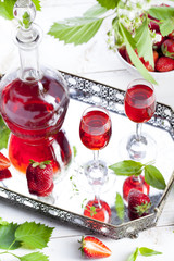 Strawberry and basil homemade liquor on a white background 