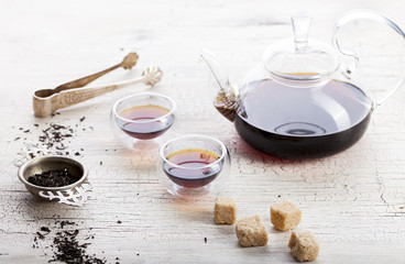Black tea in a transparent teapot and cups 