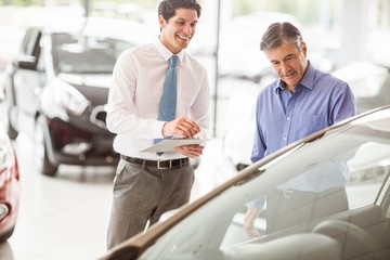 Obraz premium A man showing a car to the salesman