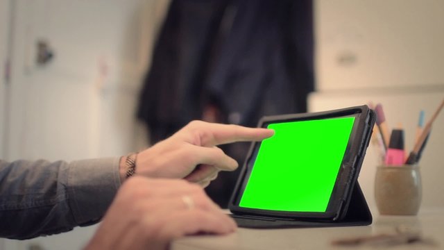 Hands working on tablet with green screen - Full HD. Close shot of hands using a tablet with green screen

