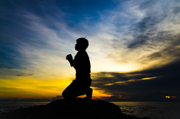 praying man on beautiful sky background