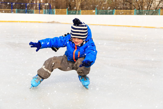 cute little boy learning to skate in winter
