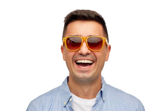 face of smiling man in shirt and sunglasses