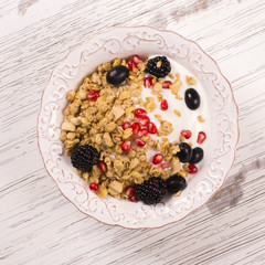 Crunchy granola with nuts, yogurt and fresh berries. Healthy breakfast concept. Top view