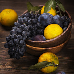 Fresh organic fruits in a wooden bowl. Rustic style. Toned image. Selective focus