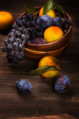 Fresh organic fruits in a wooden bowl. Rustic style. Toned image. Selective focus
