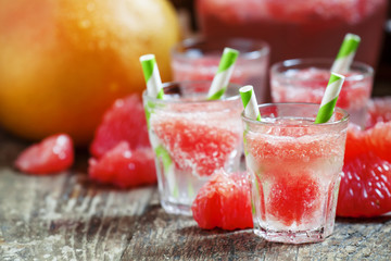 Cocktail with vodka, soda and grapefruit with striped straws, se