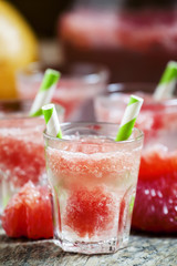 Cocktail with vodka, soda and grapefruit with striped straws, se