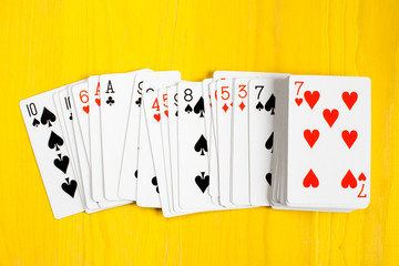 Playing cards on yellow wooden background
