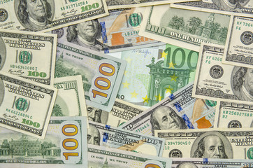 Fototapeta na wymiar 100 dollars and 100 euros banknotes as background