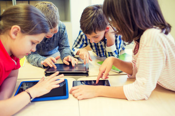 group of school kids with tablet pc in classroom