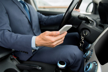 close up of man with smartphone driving car