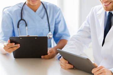 doctors with tablet pc and clipboard at hospital