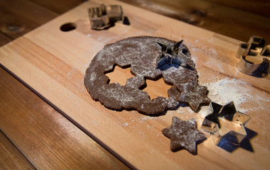 close up of ginger dough, molds and flour on board