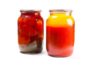 Glass jars of canned tomatoes and tomatoes juice on white backgr