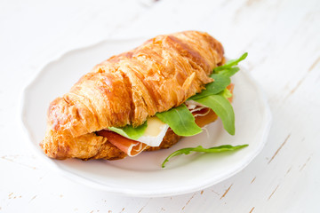Sandwich croissant with ham brie arugula