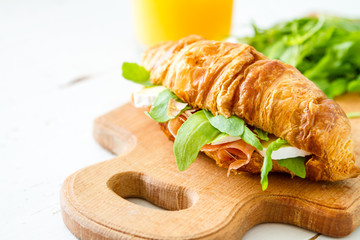 Sandwich croissant with ham brie arugula