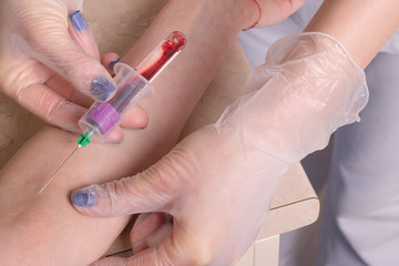 Nurse collecting a blood from young patient