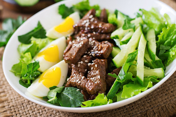 Salad with spicy beef, cucumber and eggs in the Asian style.