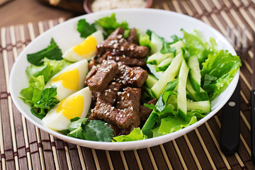 Salad with spicy beef, cucumber and eggs in the Asian style.