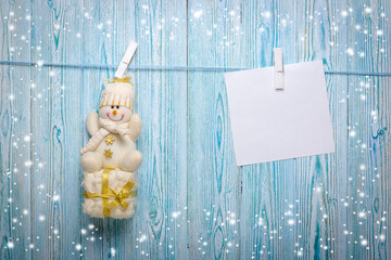 Christmas snowman hanging from a rope on a rustic background
