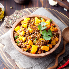 Fototapeta premium Lentil with carrot and pumpkin ragout in a wooden bowl.