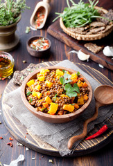 Lentil with carrot and pumpkin ragout in a wooden bowl.