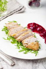 Duck breast meat with fresh salad, arugula and cherry sauce.