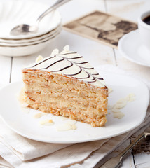 Traditional Hungarian Esterhazy cake with coffee cup and vintage postcards .