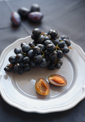 black grapes and plums on a plate