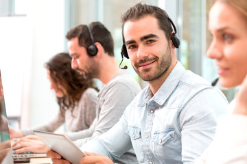 Fototapeta na wymiar Young attractive man working in a call center