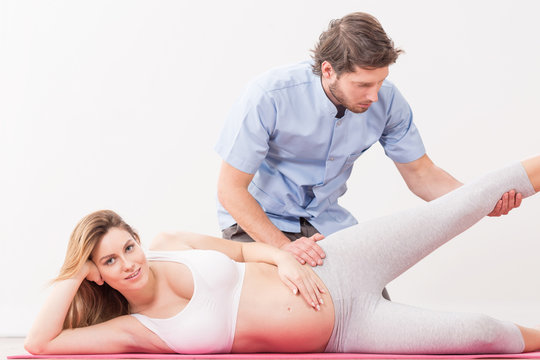 Pregnant woman exercising with physiotherapist