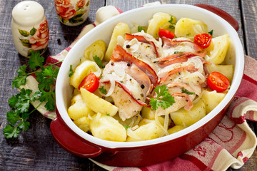 Baked potatoes with chicken and bacon on a dark wooden backgroun
