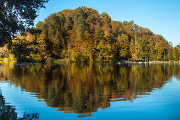 Fototapeta na wymiar Boat floating on Trakoscan lake in Zagorje, Croatia, season, autumn, Reflection of trees on water 