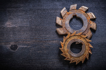 Rusty obsolete rotary cutters on wooden surface construction con