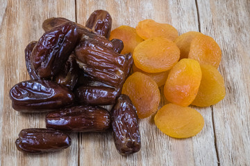 dried apricots and dried dates on a wood
