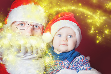 Christmas baby and Santa opening a present or gift box