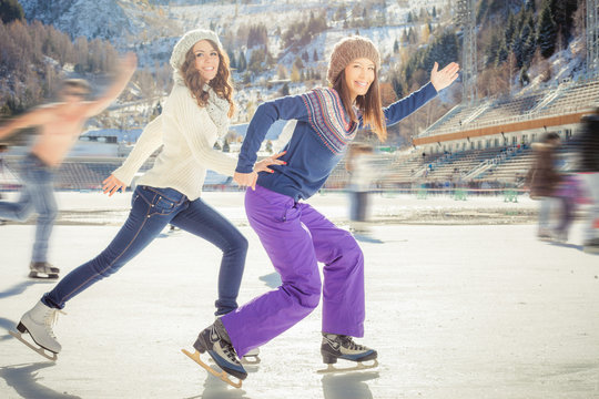 Group funny teenagers ice skating outdoor at ice rink