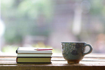 Notebook and mini old  cup on wooden table