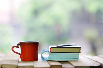 Red heart mug shaped and notebooks at windows