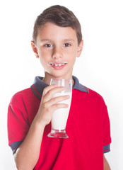 Young boy smiling while drinking glass of milk , isolated on white background