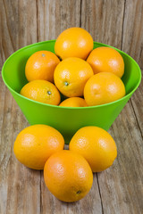 several pieces of orange fruit in a green bowl
