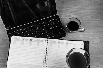 Calendar, tablet and coffee to express concepts of organization and planning: in black and white