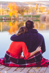 Back view of couple are resting near lake