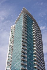 Modern high rise office or condominium with green glass and curved design.