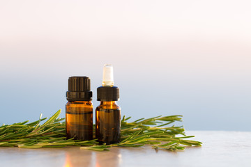 Rosemary aromatherapy essential oils in bottles on sunset 