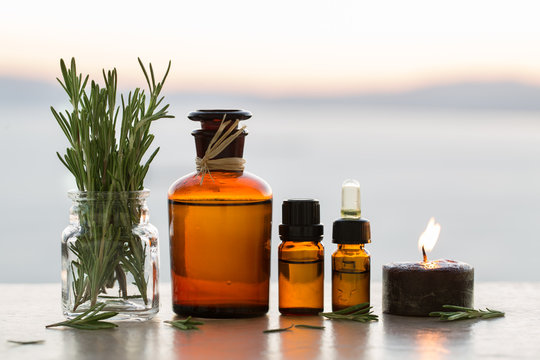 Rosemary aromatherapy essential oils in bottles on sunset 