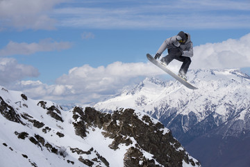 Flying snowboarder on mountains, extreme sport