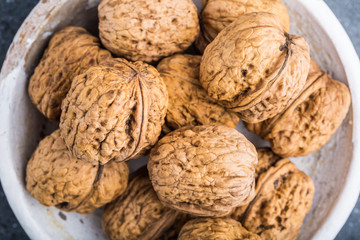Walnuts in a white bowl on a black background