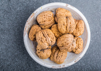 Walnuts in a white bowl on a black background
